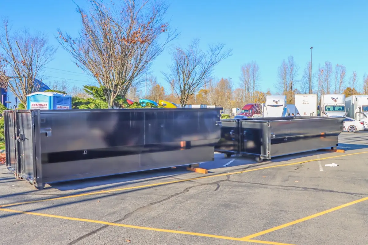 Professional dumpster rental service with roll-off container on residential driveway in Linton